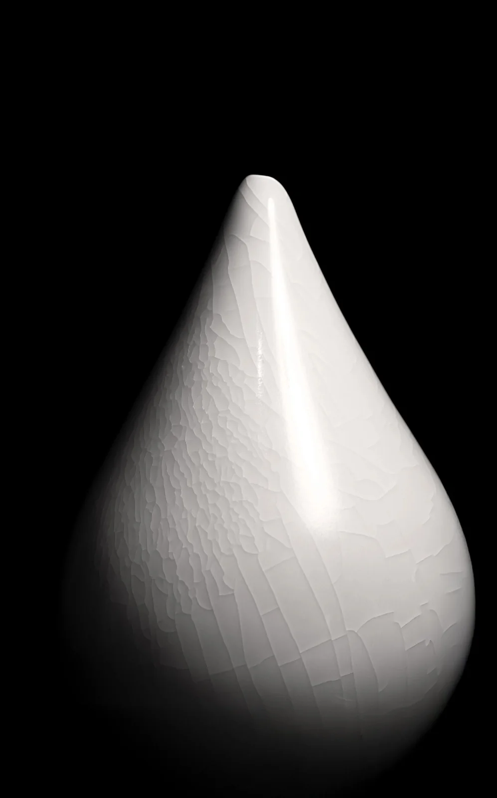 A single white pointed sculpture with a crackled surface