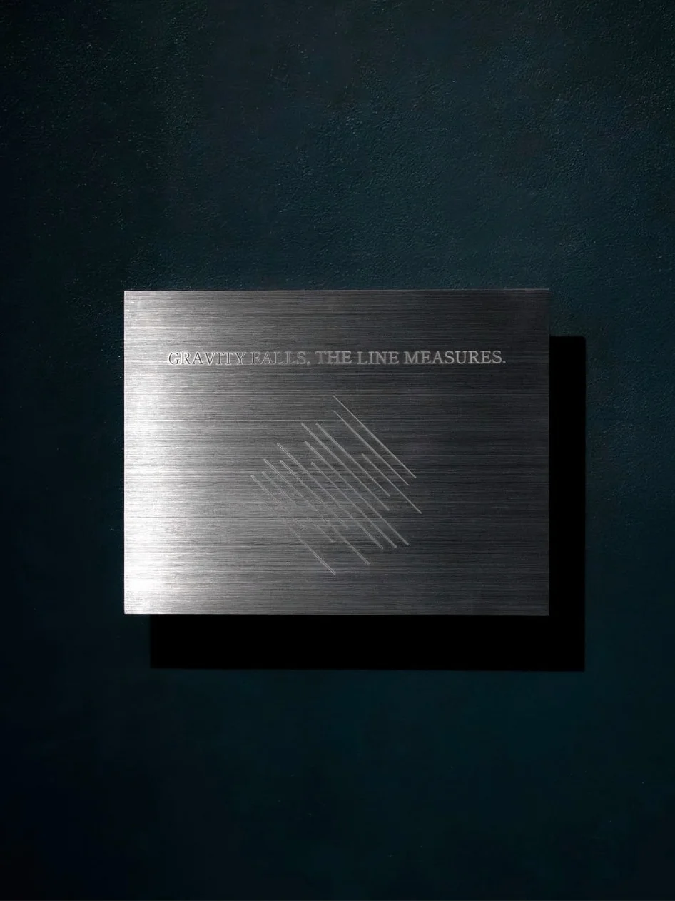 An engraved rectangular wall work on a dark blue wall