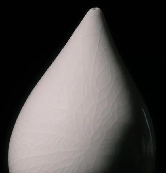Close view of a white sculpture showing fine surface fissures