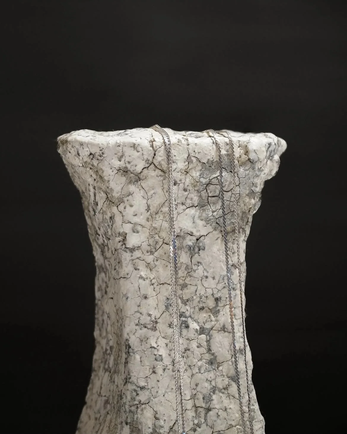 Close view of a crackled ceramic jewelry display stand