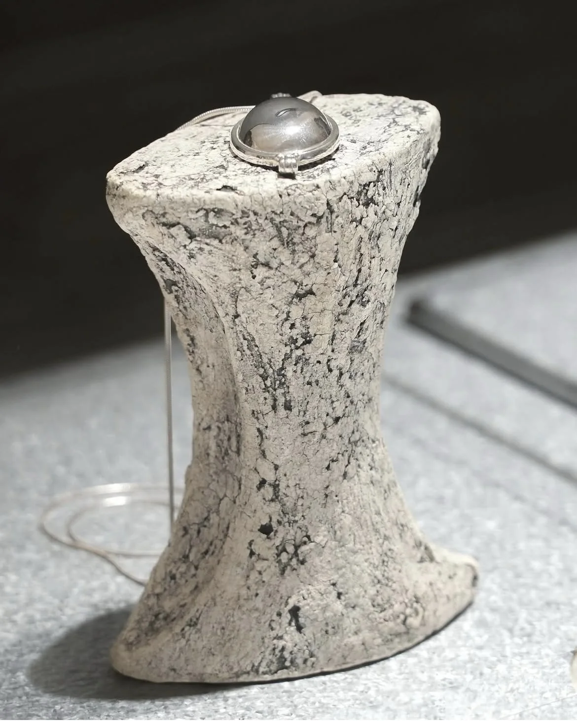 A ring resting on a tall ceramic display object