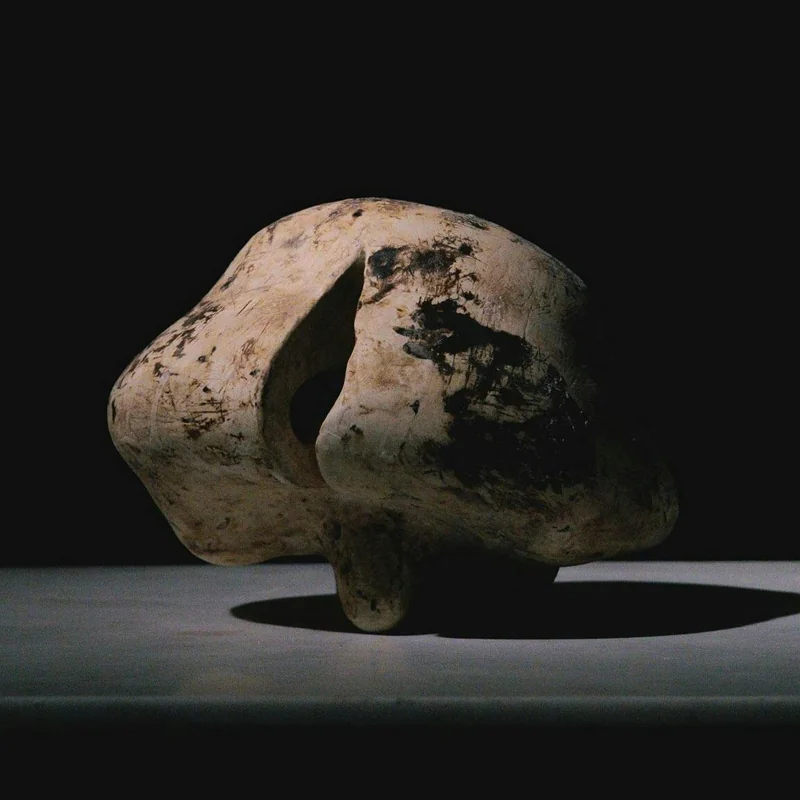 An open ceramic form resting on small points of contact.