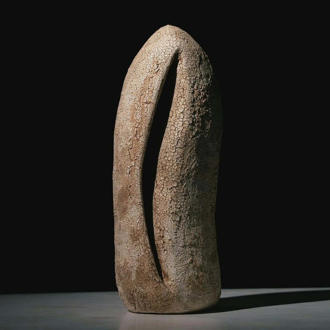 An upright ceramic form divided by a narrow opening.