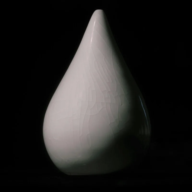 A porcelain form with crackled glaze, designed to be suspended.