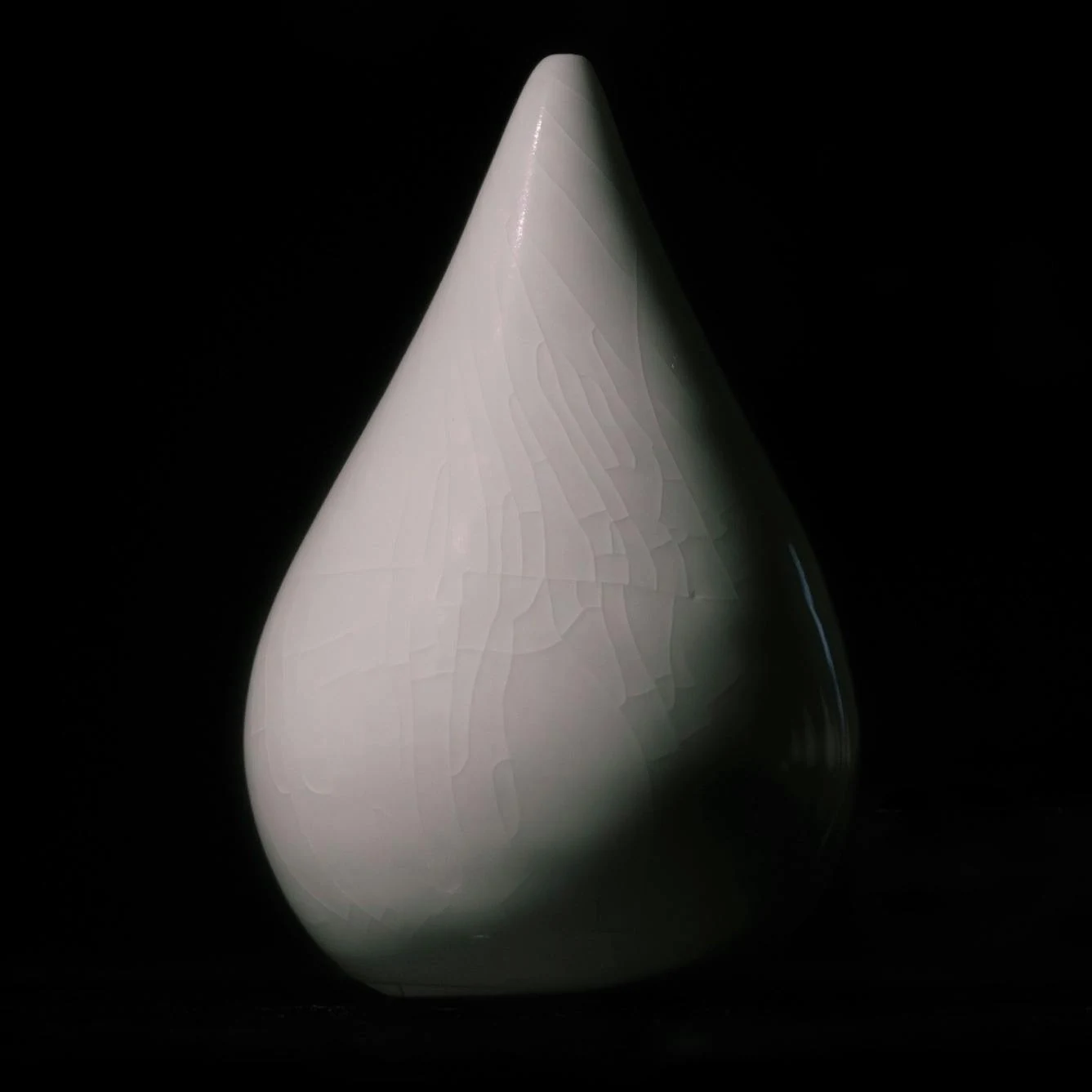 A porcelain form with crackled glaze, designed to be suspended.